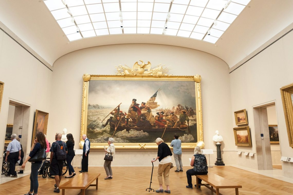 Visitors looking at a large painting in a museum gallery