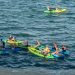 A group of kayakers paddling together on open water