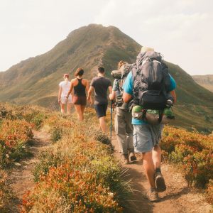 A group of hikers on a trail heading toward a mountain peak