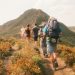 A group of hikers on a trail heading toward a mountain peak