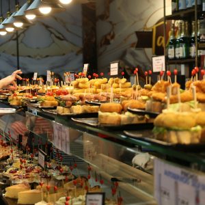 A bar counter lined with small plates of pintxos