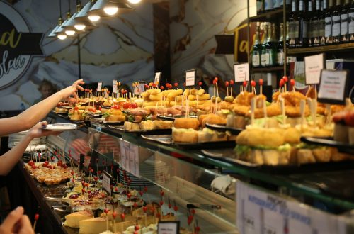 A bar counter lined with small plates of pintxos