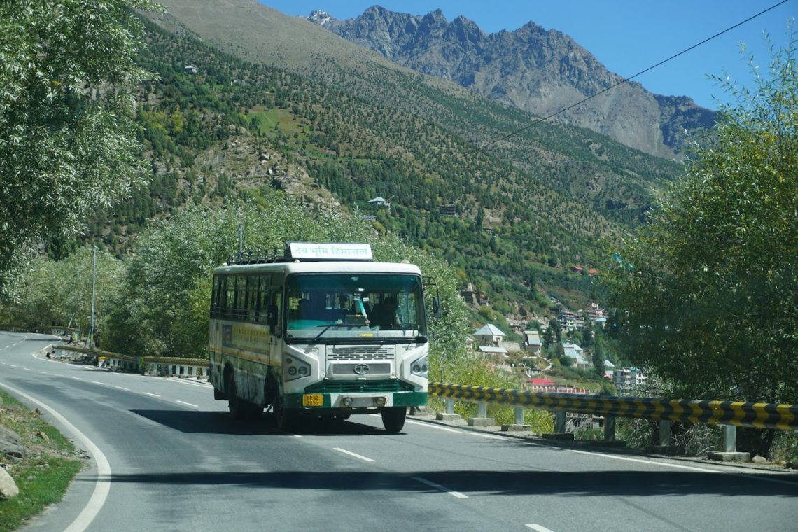 A tour bus on a road through the mountains