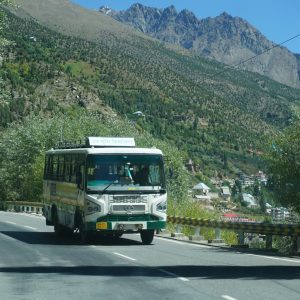 A tour bus on a road through the mountains