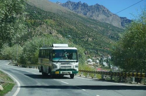A tour bus on a road through the mountains