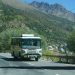 A tour bus on a road through the mountains