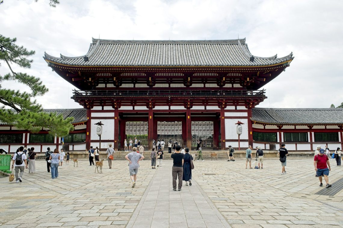 Visitors walking toward a large temple gate in Japan