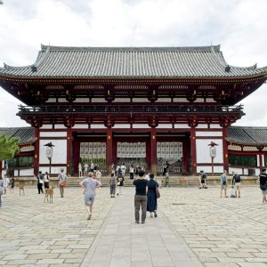 Visitors walking toward a large temple gate in Japan