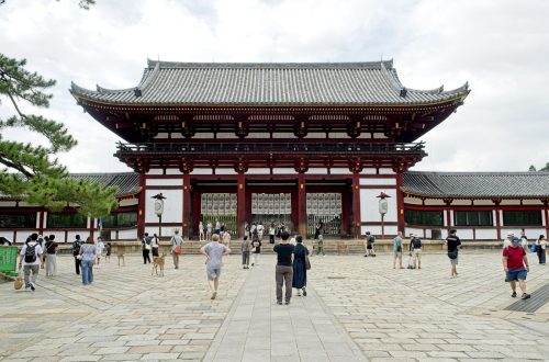 Visitors walking toward a large temple gate in Japan